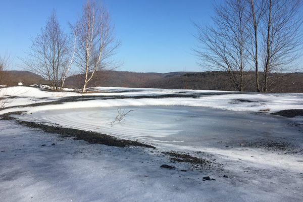 An icy pond forms just behind the brink of the viewpoint.